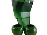 deux vases verts posés l'un à côté de l'autre sur une surface blanche