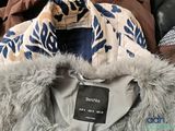 a coat with a fur collar and a tag on it