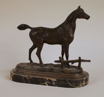 statue en bronze représentant un cheval, posée sur un socle en marbre, sur fond blanc