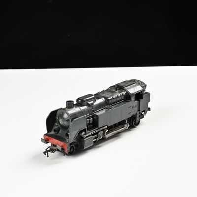 un petit train sur une surface blanche avec un fond noir