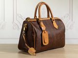 a brown and tan handbag sitting on top of a wooden table
