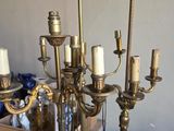 un grand chandelier en laiton surmonté de cinq bougies