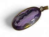 un gros plan d'un pendentif en verre violet sur fond blanc