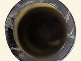 a black pipe with a hole in it on a white surface