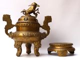 a large brass teapot with a bird on top of it