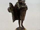 bronze statue of a man holding a book on a marble base