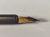 a close up of a fountain pen on a white surface