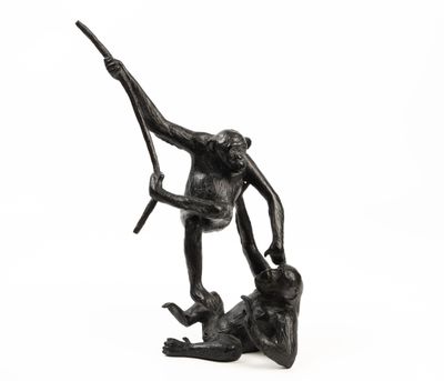 statue of a monkey holding a branch on a rock