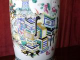 a vase with a painting on it sitting on a table