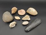 quelques rochers et un objet en pierre posés sur une surface noire
