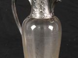 a glass vase with a silver lid on a black background