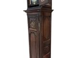 a tall wooden clock tower with a glass door
