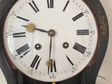 a black and gold clock with roman numerals on it