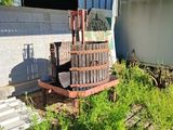 un vieux tonneau en bois posé dans l'herbe à côté d'un bâtiment