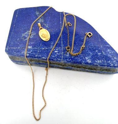 gold plated necklace with a blue lapis stone on a white background