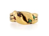 un gros plan d'une bague en or sur laquelle est représenté un serpent vu de profil