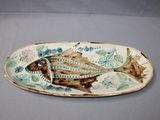 a plate with a fish design on it on a table