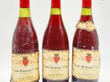 trois bouteilles de vin posées les unes à côté des autres sur une surface blanche