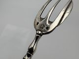 a silver fork with a black handle on a table