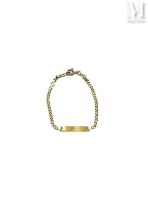 a close up of a gold bracelet with a bar on it