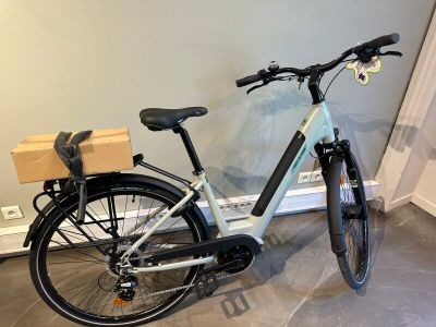 un vélo garé dans une pièce, avec un carton à l'arrière