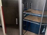 a stainless steel refrigerator in a kitchen with a lot of shelves