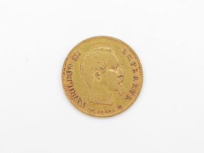 gros plan d'une pièce d'or sur une surface blanche