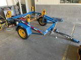 a blue trailer with yellow wheels in a garage