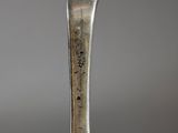 a silver spoon with a bird on it on a table