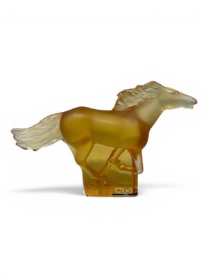 yellow glass horse figurine on a white surface with a white background