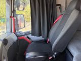 a seat in the back of a bus with a red seat belt