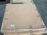 Plusieurs palettes de carton sont empilées sur des palettes dans un entrepôt