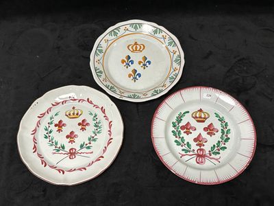 trois assiettes ornées de motifs variés, posées sur un fond noir