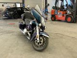 a motorcycle parked in a garage with a forklift in the background