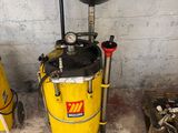 a yellow bucket with a black lid sitting next to a yellow bucket with a black lid