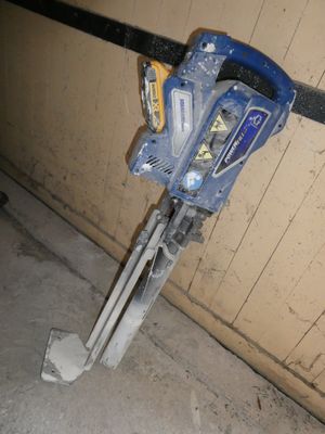 une photo d'une perceuse bleue et blanche dans un garage
