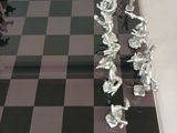 a glass chess board with a bunch of figurines on it