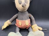 mickey mouse plush toy sitting on a black surface