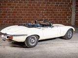 a white convertible car parked in front of a brick wall