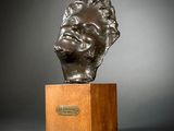 an image of a bronze bust of a man on a wooden pedestal
