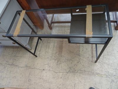 Un bureau en verre et piètement en métal