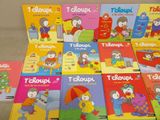 several children ' s books are lined up on a table