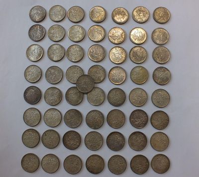une pile de vieilles pièces de monnaie posée sur une surface blanche