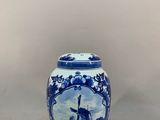 a blue and white vase with a picture of a man on a boat