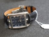 une montre munie d'une étiquette, posée sur une table