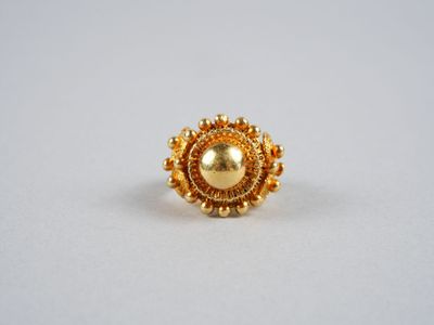 gros plan d'une bague en or sur une surface blanche