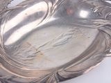 a silver plate with a bird on it on a table