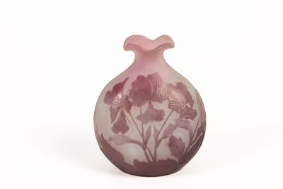 un vase orné d'un motif floral sur une surface blanche