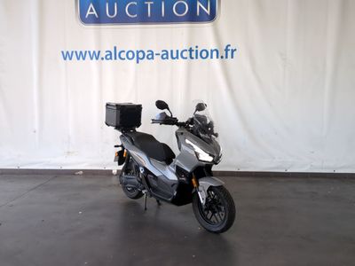 un scooter garé devant un panneau