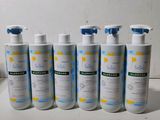 six bottles of baby lotion sitting on a counter top next to a bottle of lotion